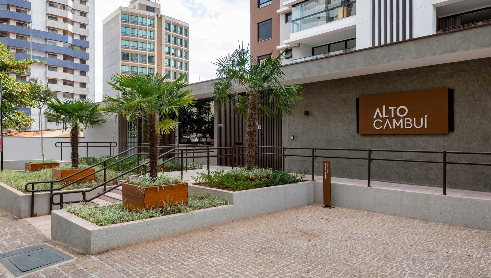Acesso do edifício Alto Cambuí com concreto e paisagismo